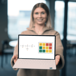 Ett foto av en kvinna som visar sk&auml;rmen p&aring; en laptop med bild p&aring; processbaserad riskanalys i 2c8 Apps.